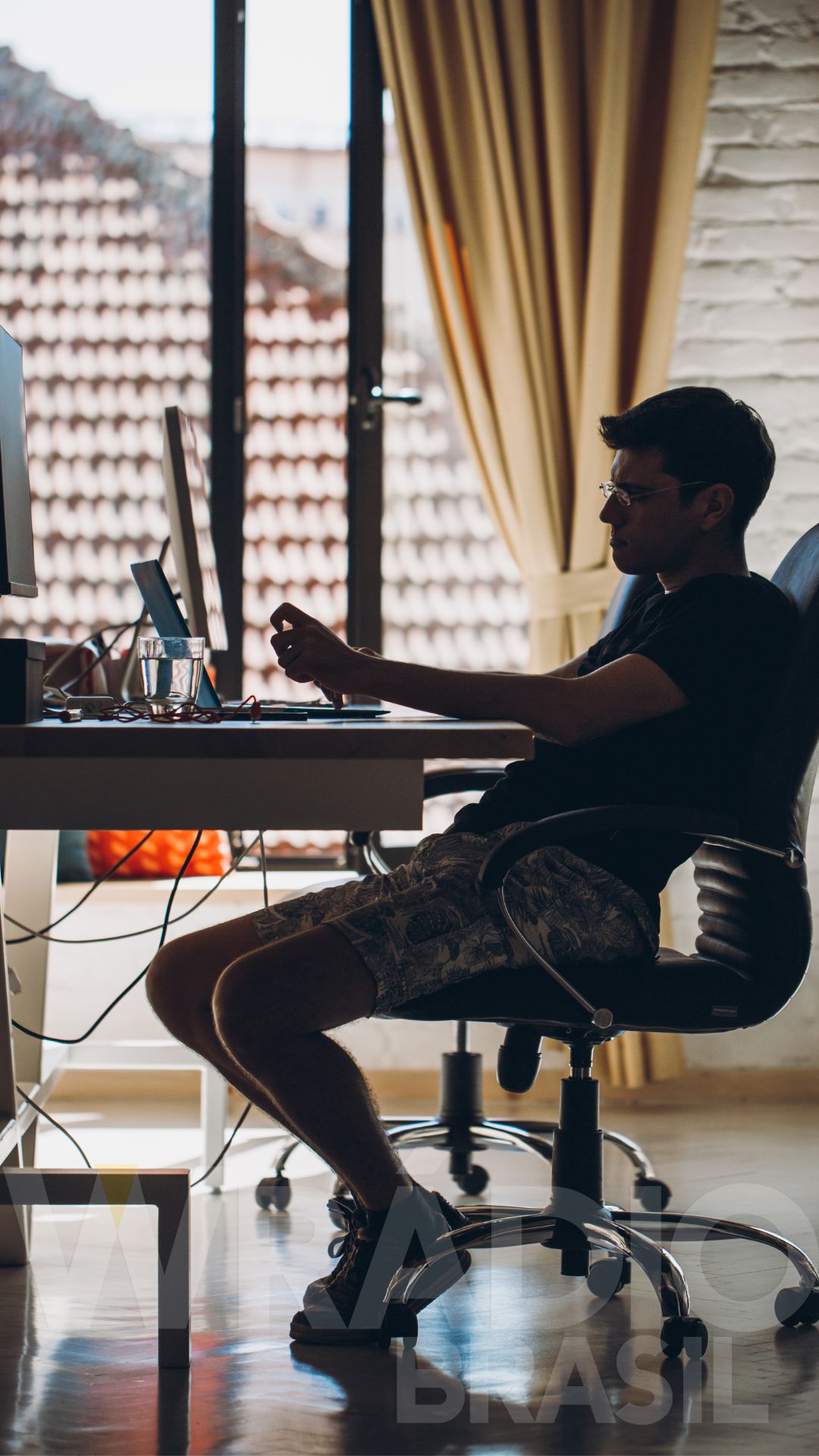 Mesa de trabalho com documentos e computador, ilustrando a produção de notícias baseada em comunicados de imprensa e jornalismo sentado.